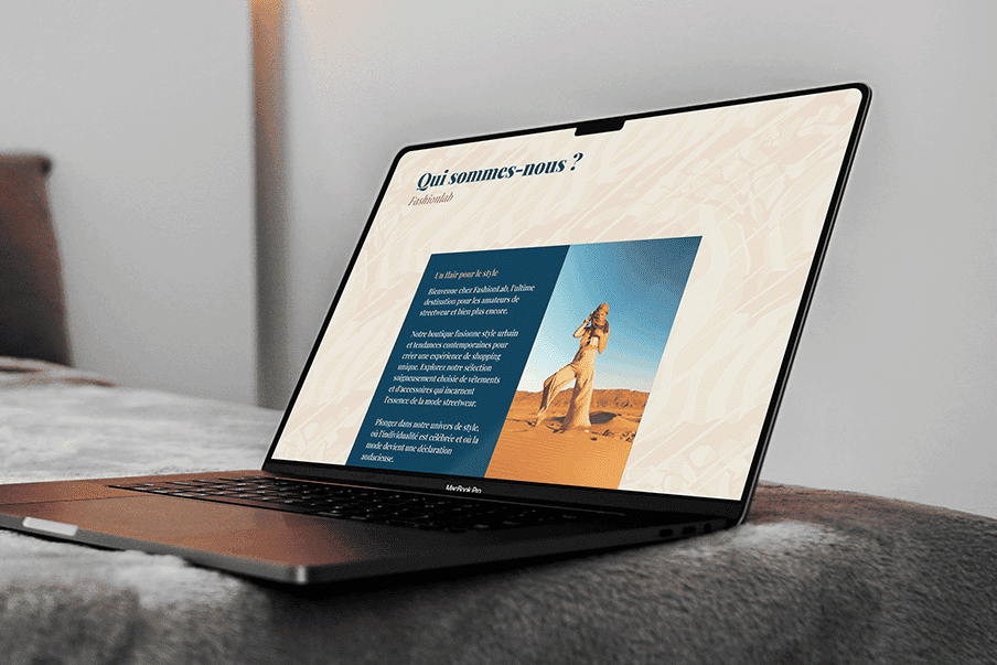 Présentation du site sur McBook Pro posé sur un lit.